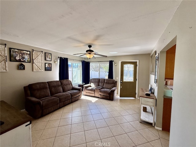 living area featuring light tile patterned floors and ceiling fan