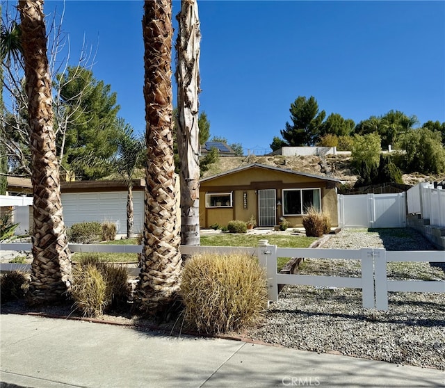 view of front of home with a fenced front yard, stucco siding, and a gate