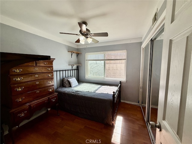 bedroom featuring visible vents, baseboards, a ceiling fan, and wood finished floors