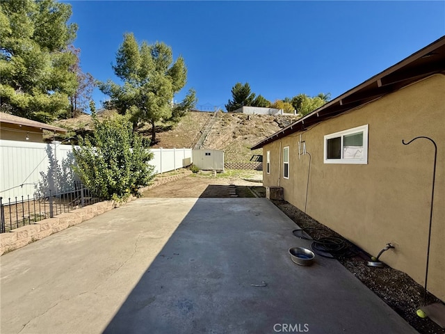 view of patio / terrace with an outdoor structure and a fenced backyard