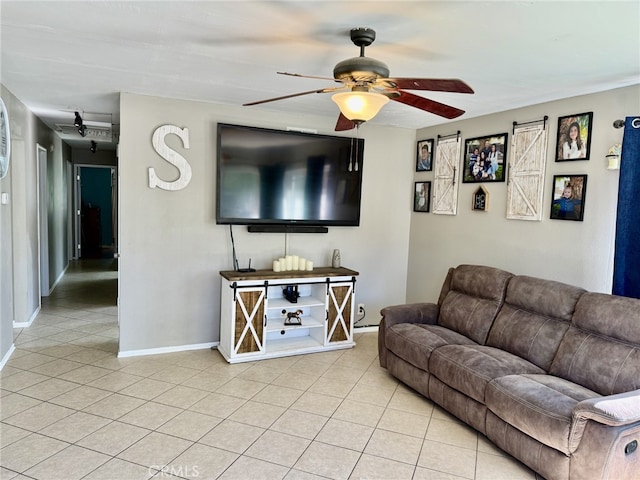 living room featuring baseboards, light tile patterned flooring, and a ceiling fan