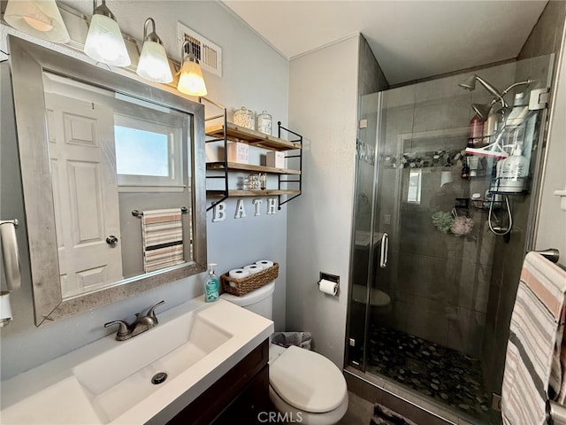 full bathroom featuring visible vents, a stall shower, toilet, and vanity