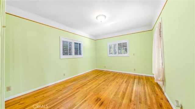 spare room with light wood-style flooring and baseboards