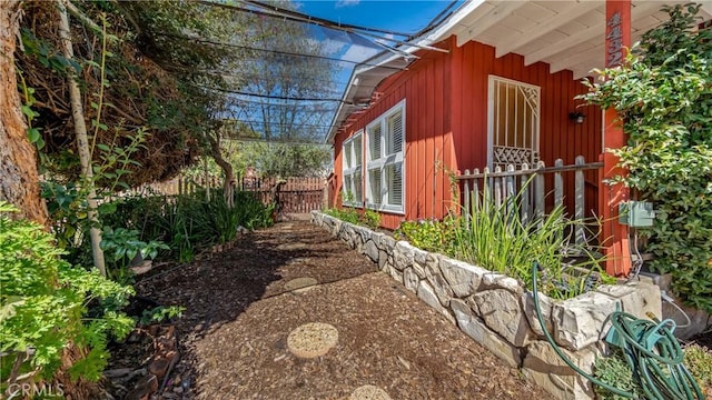 view of home's exterior with board and batten siding and fence