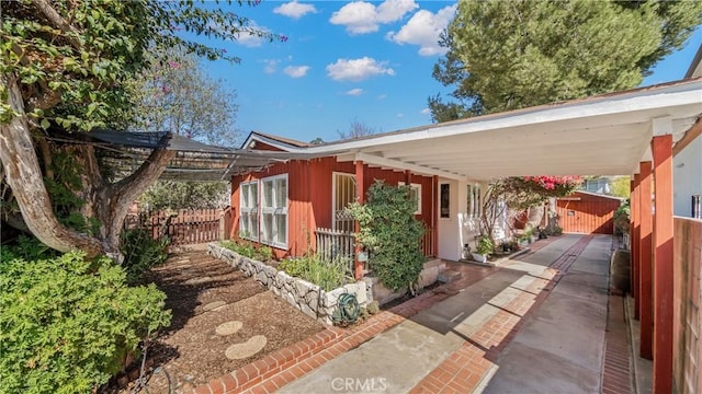 view of property exterior featuring a carport and fence