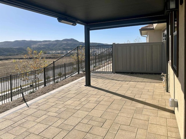 view of patio featuring a mountain view and fence