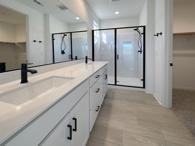 full bathroom with a spacious closet, visible vents, a stall shower, and a sink