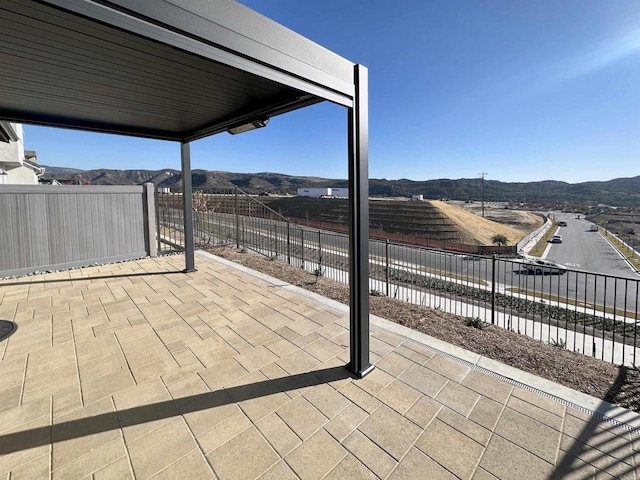 view of patio / terrace featuring fence and a mountain view