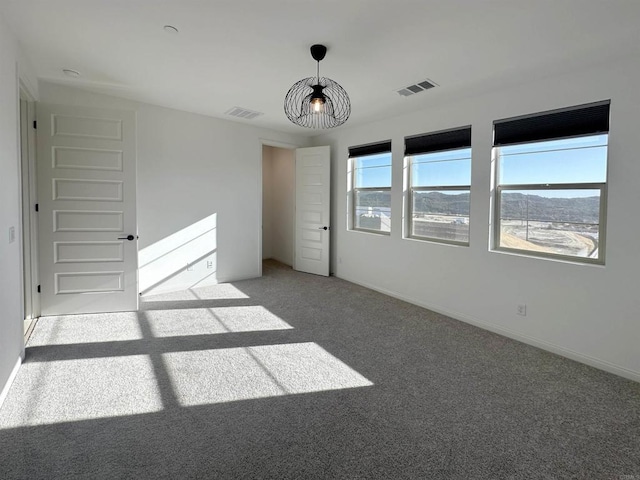 unfurnished bedroom featuring baseboards, visible vents, and light carpet