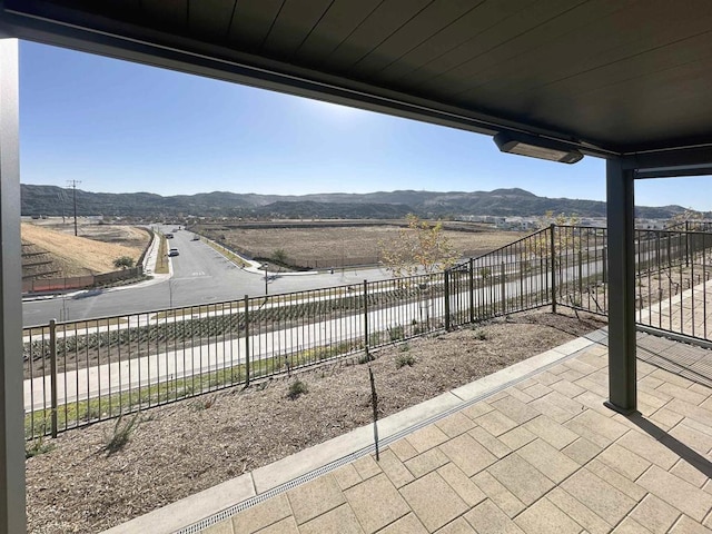 view of patio / terrace featuring a mountain view and fence