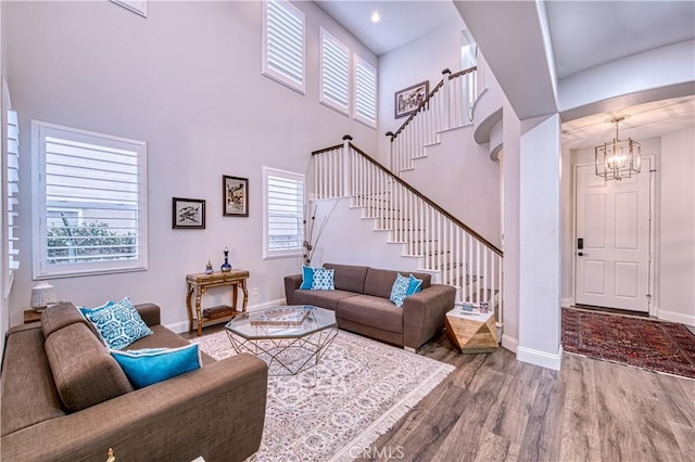 16 Lyra Way, Coto De Caza, CA 92679 - living room with a chandelier, stairs, wood finished floors, baseboards, and a towering ceiling
