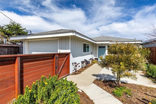 view of front of property featuring a garage and fence