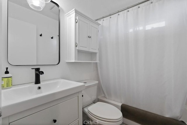 bathroom with shower / tub combo with curtain, vanity, and toilet