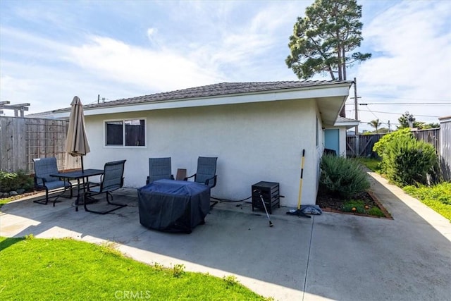 back of property featuring stucco siding, a patio, and fence