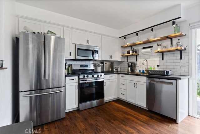 kitchen with a sink, dark countertops, open shelves, and stainless steel appliances