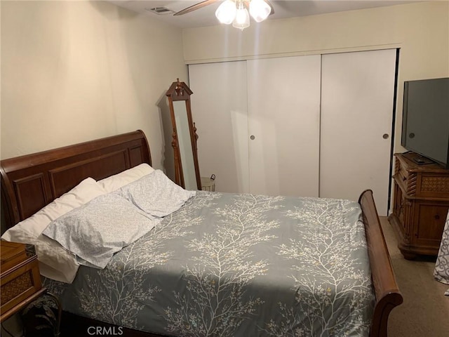 bedroom featuring a ceiling fan, visible vents, a closet, and carpet floors