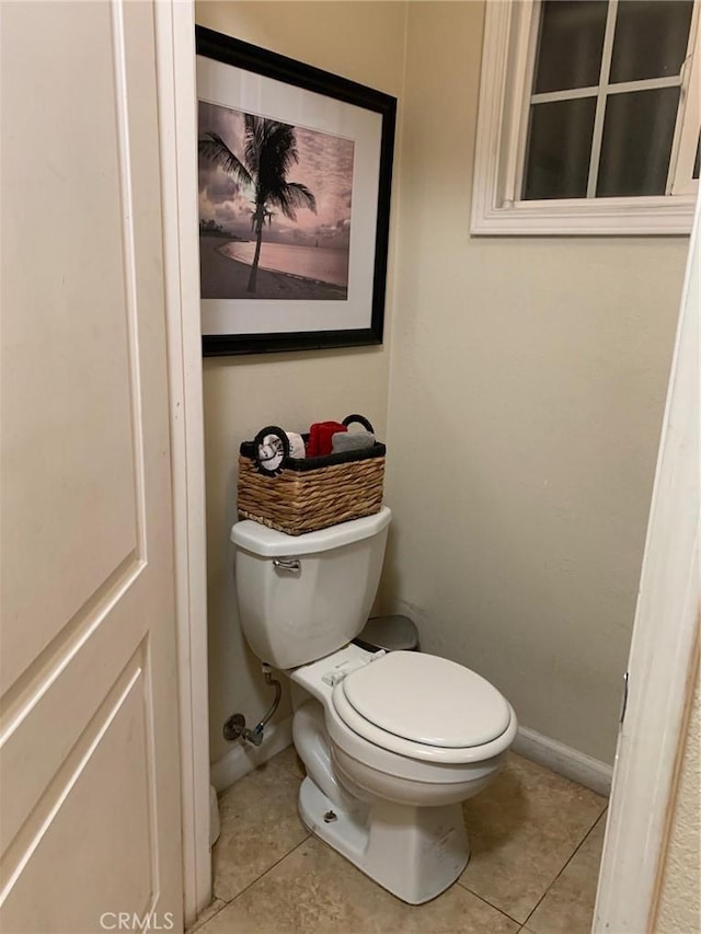 bathroom featuring tile patterned floors, baseboards, and toilet