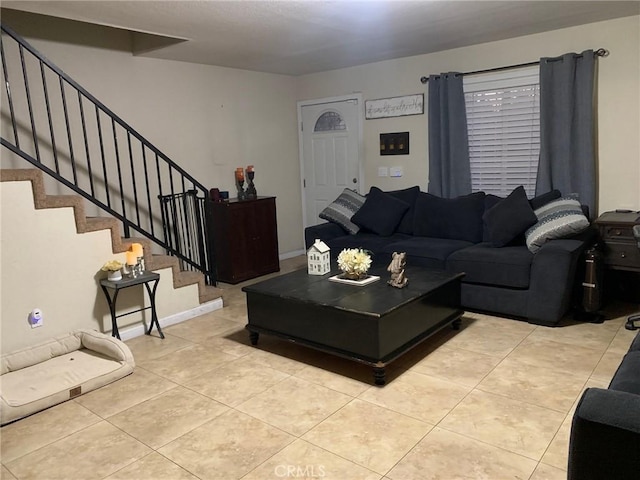 tiled living area featuring stairway and baseboards