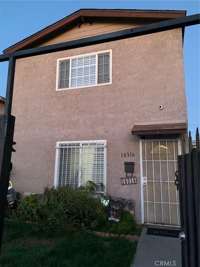 view of front facade featuring central AC unit and stucco siding