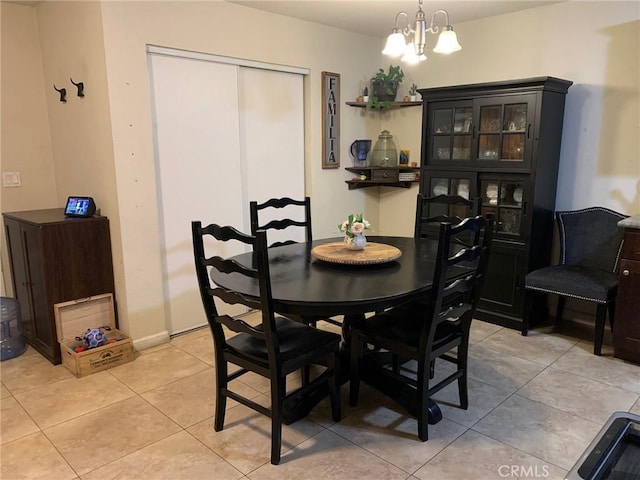 dining space featuring light tile patterned floors and a chandelier