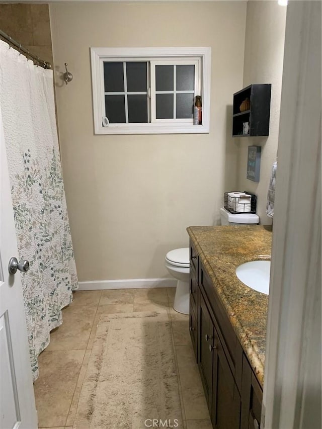 bathroom with curtained shower, toilet, vanity, and baseboards