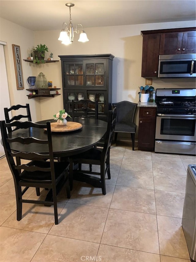 dining room with light tile patterned floors and an inviting chandelier