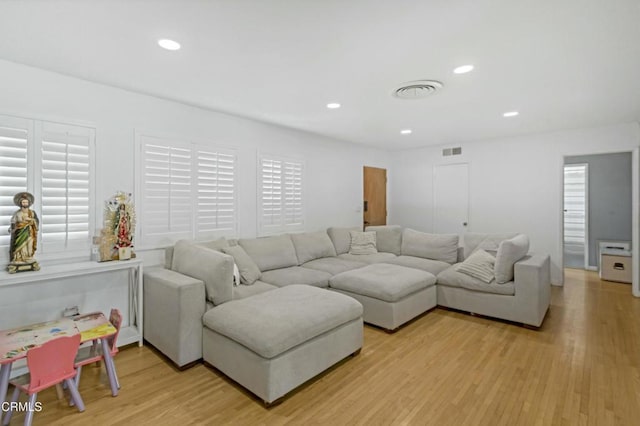 living room with recessed lighting, visible vents, and light wood finished floors