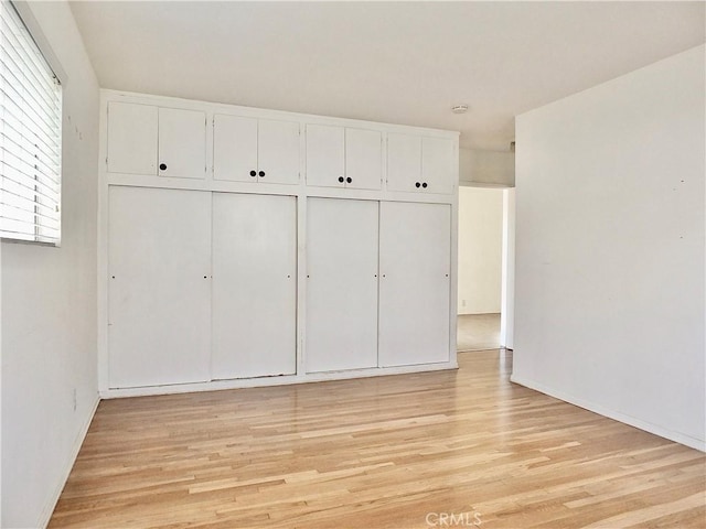 unfurnished bedroom with a closet and light wood-type flooring