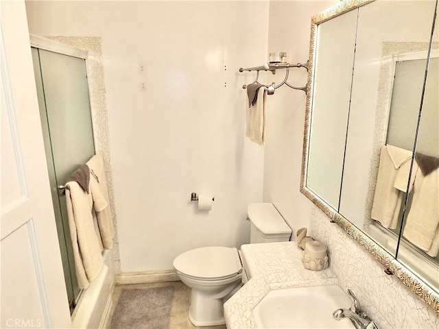 bathroom with toilet, baseboards, and a sink