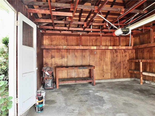 garage with wooden walls and a garage door opener