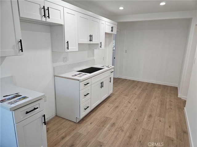 kitchen featuring light wood finished floors, white cabinetry, recessed lighting, and light countertops