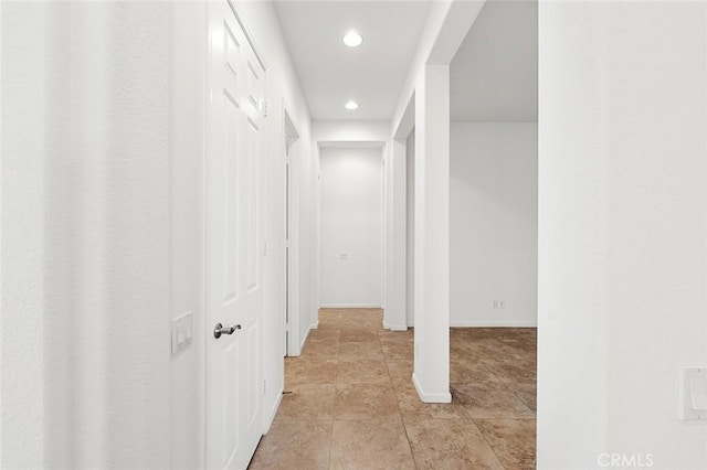 hall featuring recessed lighting, baseboards, and light tile patterned flooring