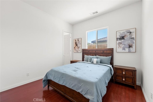 bedroom featuring visible vents, baseboards, and wood finished floors