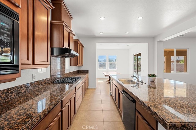 kitchen with light tile patterned flooring, a sink, stainless steel gas stovetop, under cabinet range hood, and dishwasher