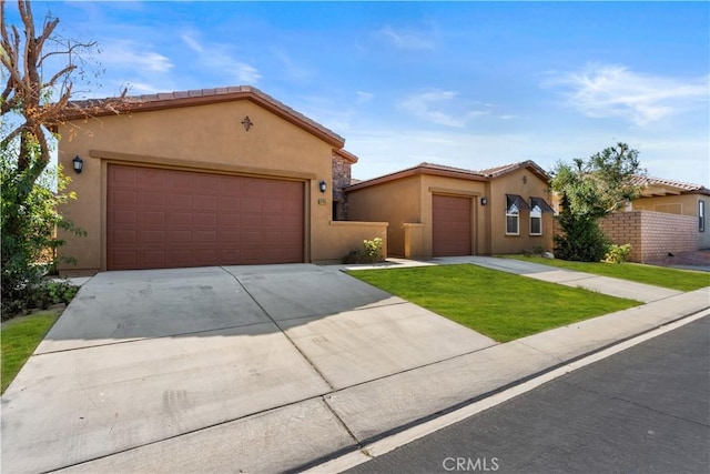 view of front of house featuring stucco siding, driveway, an attached garage, and a tile roof