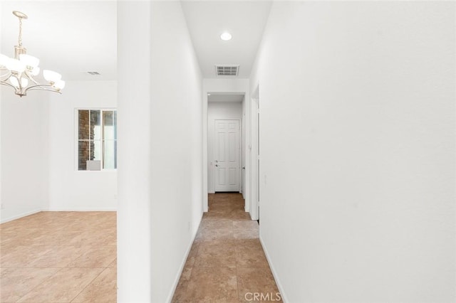 hallway with a notable chandelier, visible vents, recessed lighting, and baseboards