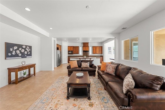 living room with recessed lighting, visible vents, and baseboards