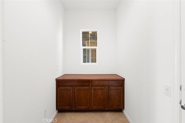 interior space with light tile patterned floors and baseboards