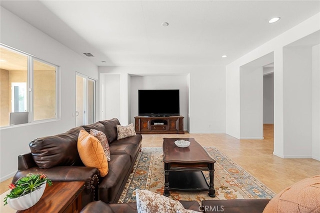 living area with recessed lighting, visible vents, and baseboards