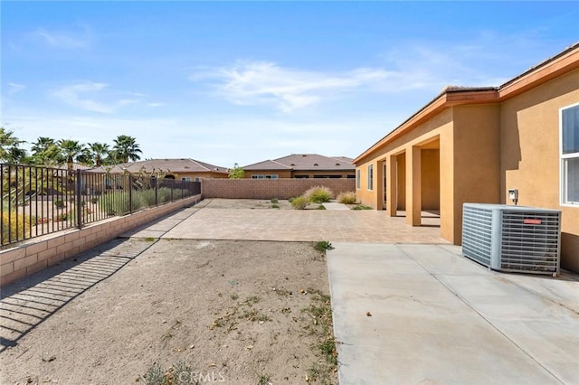 view of yard featuring a patio area, central air condition unit, and a fenced backyard