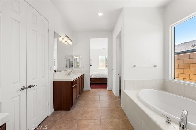 ensuite bathroom featuring vanity, a bath, a healthy amount of sunlight, and ensuite bathroom