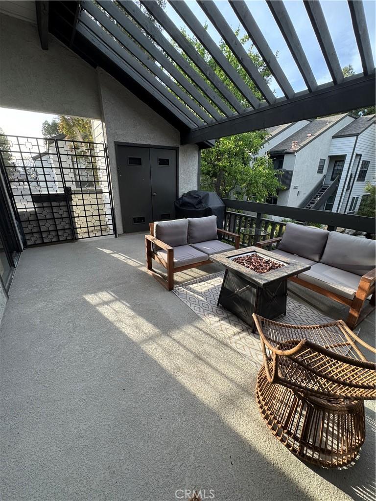 view of patio with area for grilling, an outdoor living space with a fire pit, and a pergola