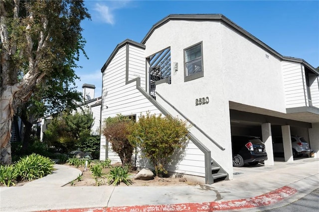 view of home's exterior with covered parking and stucco siding