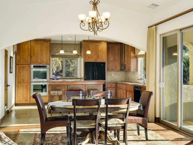 dining area with arched walkways, visible vents, a chandelier, and light tile patterned floors