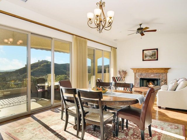 dining area with a wealth of natural light, a mountain view, a fireplace, and light wood-style floors