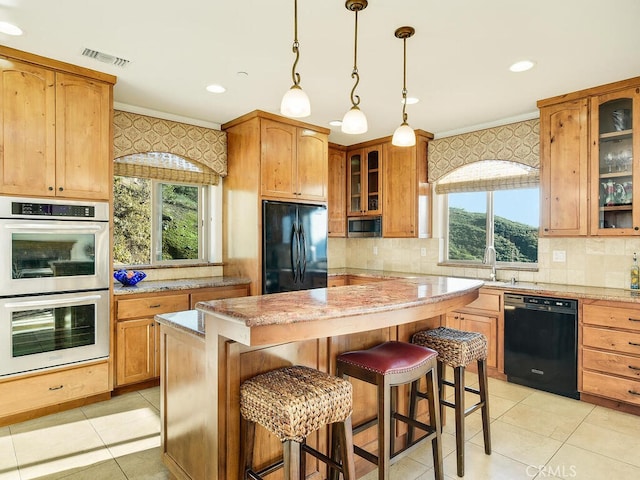 kitchen with visible vents, black appliances, ornamental molding, a breakfast bar area, and wallpapered walls