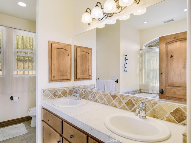 bathroom featuring a sink, visible vents, toilet, and a bath