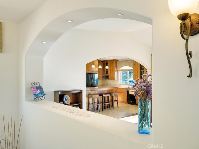 interior space featuring arched walkways, recessed lighting, and a sink