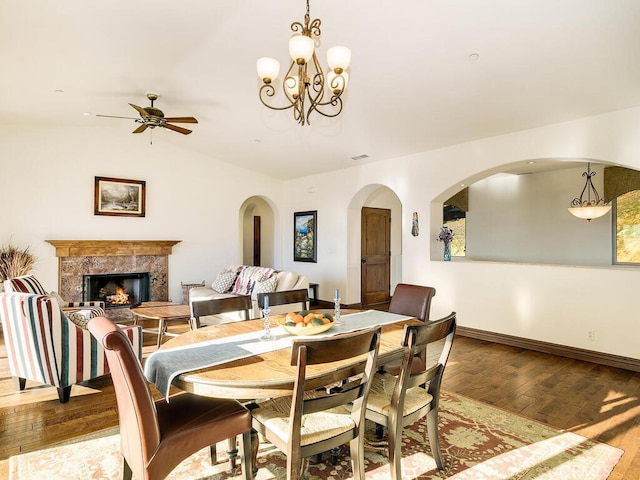 dining space featuring visible vents, ceiling fan, baseboards, a fireplace, and hardwood / wood-style flooring