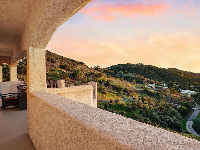 view of patio with a mountain view and a balcony